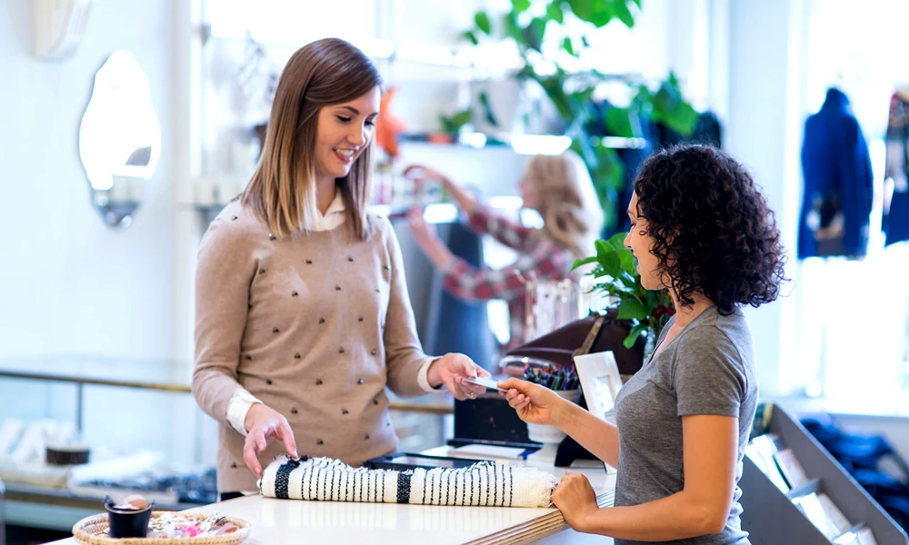 Une femme payant dans une boutique de vêtements